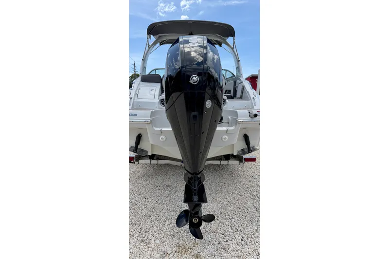 Slide: The Image of 2022 Crownline 260 XSS boat with powerful outboard motor, displayed on gravel. - 32