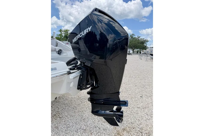 Slide: The Image of 2022 Crownline 260 XSS with Mercury outboard motor, parked on gravel under a cloudy sky. - 33
