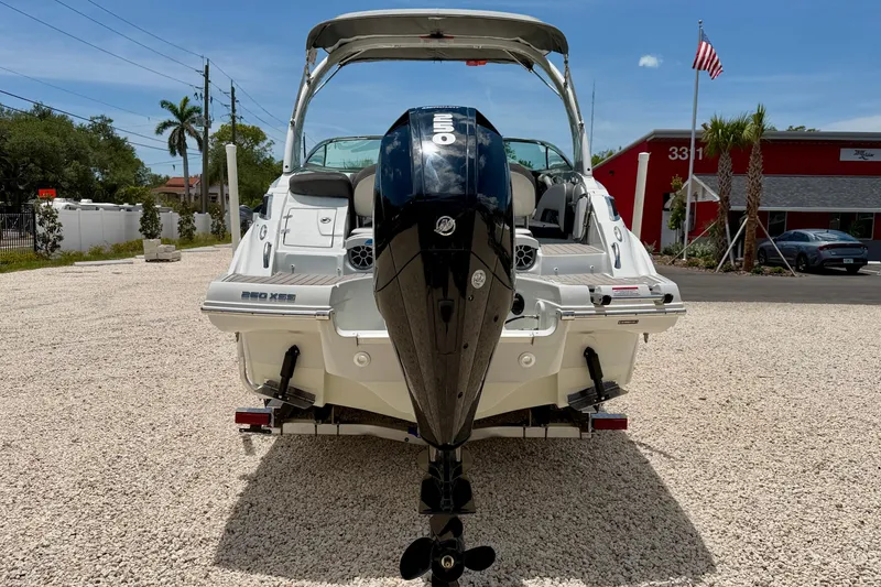Slide: The Image of 2022 Crownline 260 XSS boat with outboard motor, parked on gravel lot. - 6