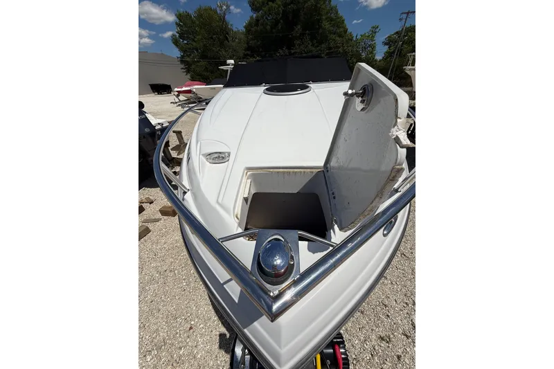 Slide: The Image of 2011 Crownline 236 SC boat with open hatch, parked outdoors. - 12