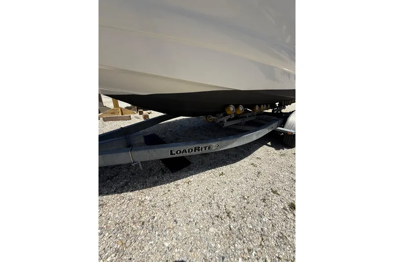 Slide: The Image of 2011 Crownline 236 SC boat on Load Rite trailer, parked on gravel. - 14