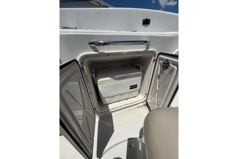 Slide: The Image of Open storage compartment on 2011 Crownline 236 SC boat, featuring a cooler inside. - 28