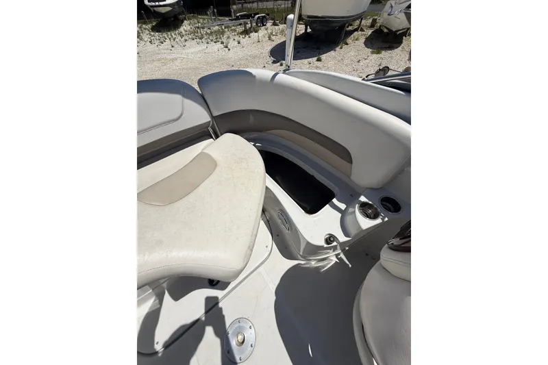 Slide: The Image of 2011 Crownline 236 SC boat interior with white seating and storage compartment. - 34