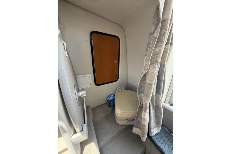 Slide: The Image of 2011 Crownline 236 SC cabin interior with compact toilet and curtain. - 39