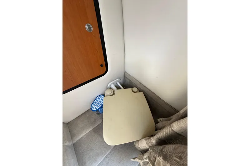 Slide: The Image of Interior of 2011 Crownline 236 SC boat showing compact toilet area. - 40