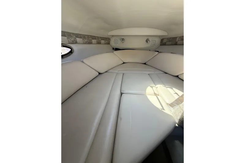 Slide: The Image of 2011 Crownline 236 SC cabin interior with beige upholstery and circular windows. - 44