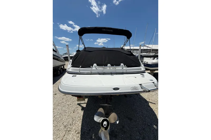 Slide: The Image of 2011 Crownline 236 SC boat with black canopy, docked under clear blue sky. - 52