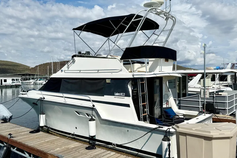 The Image of 1990 Luhrs 3400 Motor Yacht docked at marina under cloudy sky. - 1