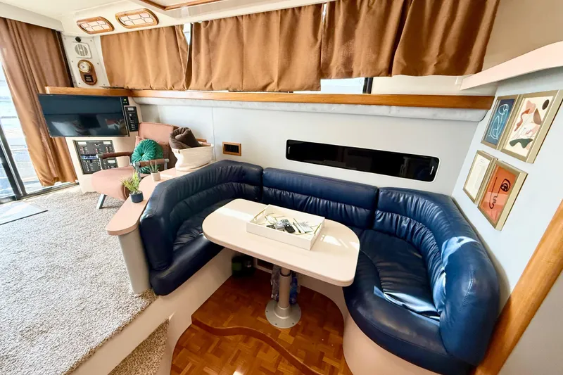 Slide: The Image of 1990 Luhrs 3400 Motor Yacht interior with blue seating, table, and decor. - 15