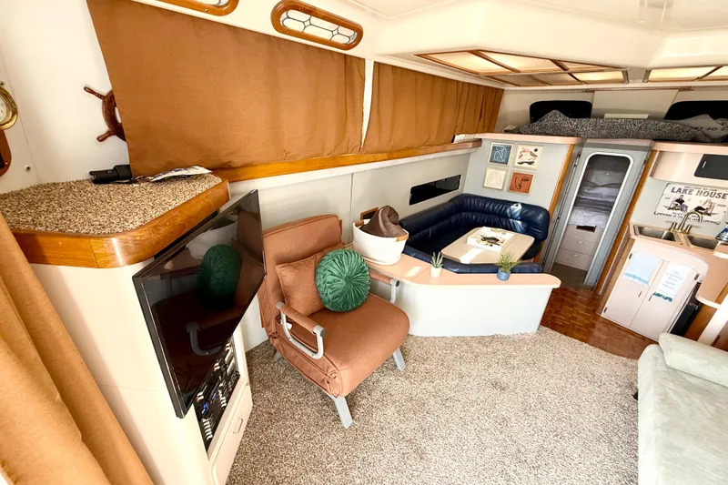 Slide: The Image of 1990 Luhrs 3400 Motor Yacht interior with cozy seating, TV, and kitchenette. - 16