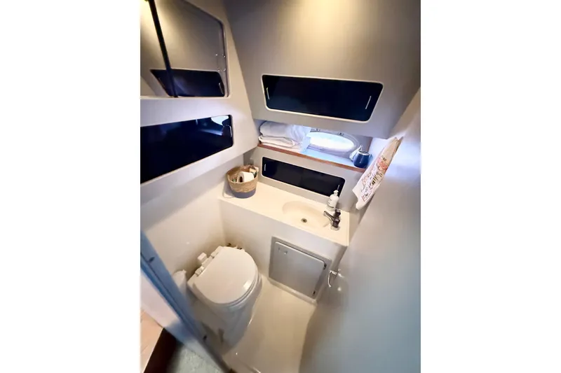 Slide: The Image of 1990 Luhrs 3400 Motor Yacht bathroom with toilet, sink, and storage. - 17