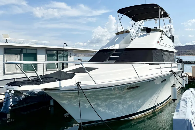 Slide: The Image of 1990 Luhrs 3400 Motor Yacht docked, featuring sleek design and covered flybridge. - 2