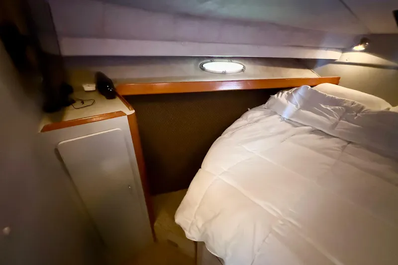 Slide: The Image of Cozy cabin interior of 1990 Luhrs 3400 Motor Yacht with bed and storage. - 20