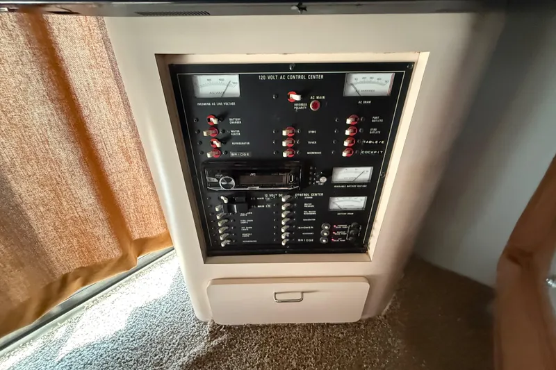 Slide: The Image of Control panel of a 1990 Luhrs 3400 Motor Yacht, featuring various switches and meters. - 23