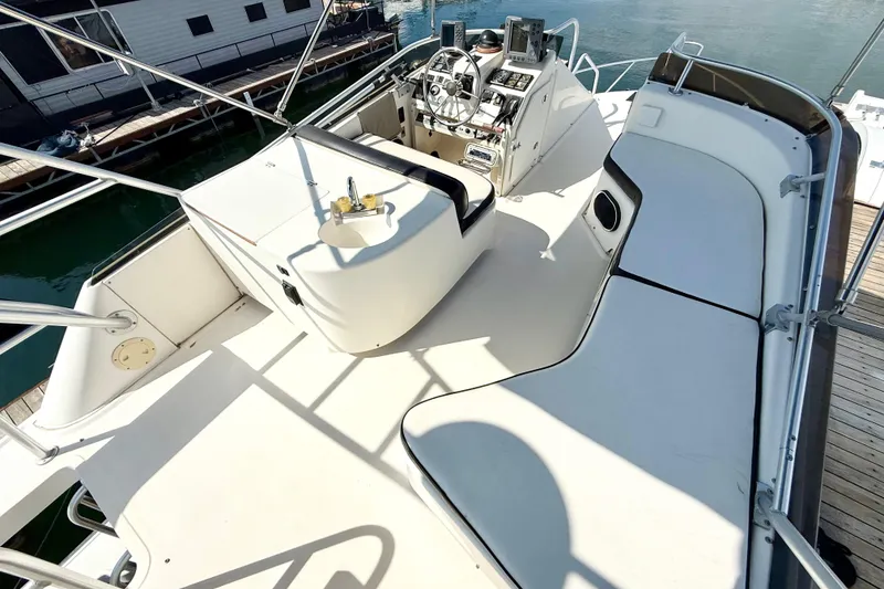 Slide: The Image of 1990 Luhrs 3400 Motor Yacht deck with helm, seating, and sink. - 25