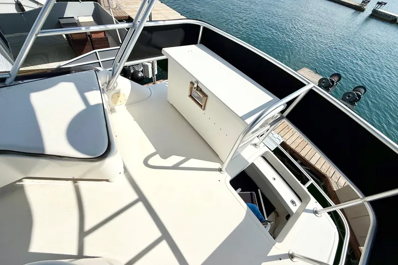 Slide: The Image of 1990 Luhrs 3400 Motor Yacht deck with seating and storage, docked by the water. - 26
