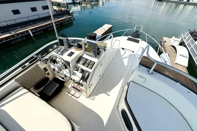 Slide: The Image of 1990 Luhrs 3400 Motor Yacht helm with navigation equipment, docked at marina. - 27