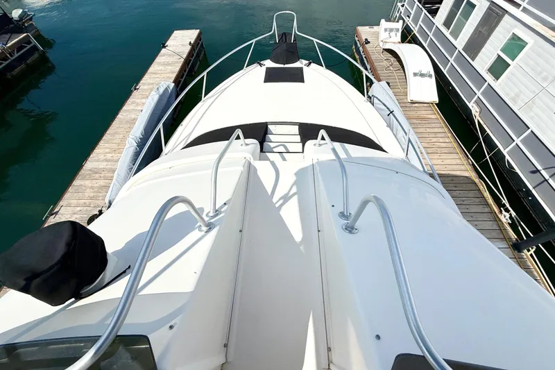 Slide: The Image of 1990 Luhrs 3400 Motor Yacht docked, view from bow, surrounded by calm water. - 28