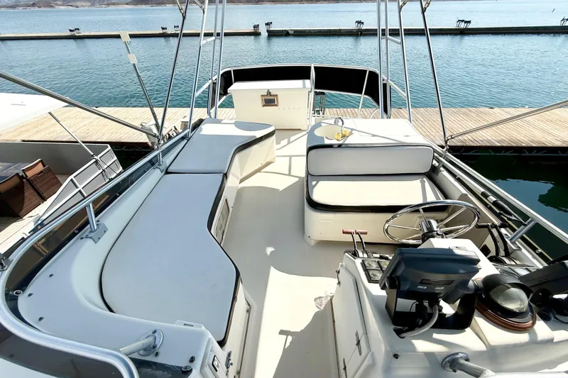 Slide: The Image of 1990 Luhrs 3400 Motor Yacht helm with seating, docked by calm waters. - 29