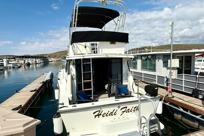 Slide: The Image of 1990 Luhrs 3400 Motor Yacht docked at marina, rear view with seating area. - 3