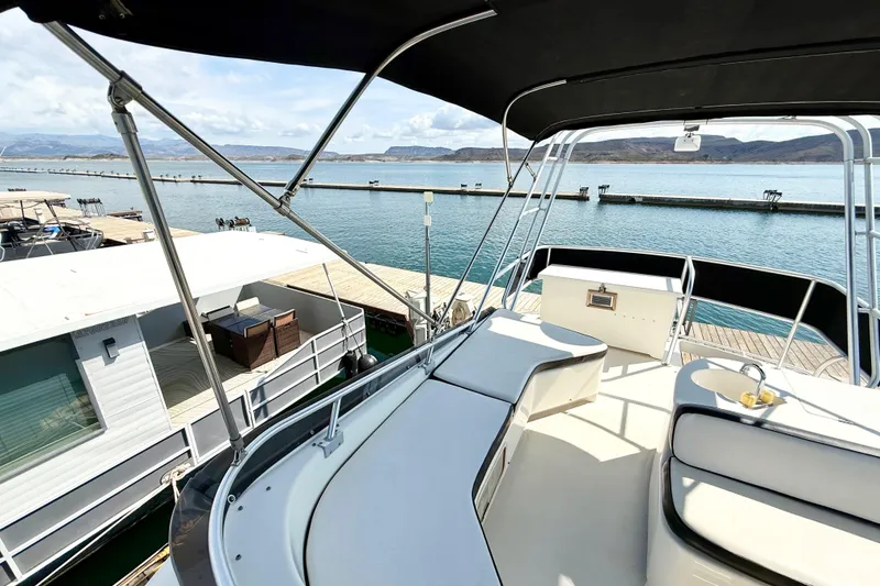 Slide: The Image of 1990 Luhrs 3400 Motor Yacht docked, featuring spacious deck and scenic waterfront view. - 31