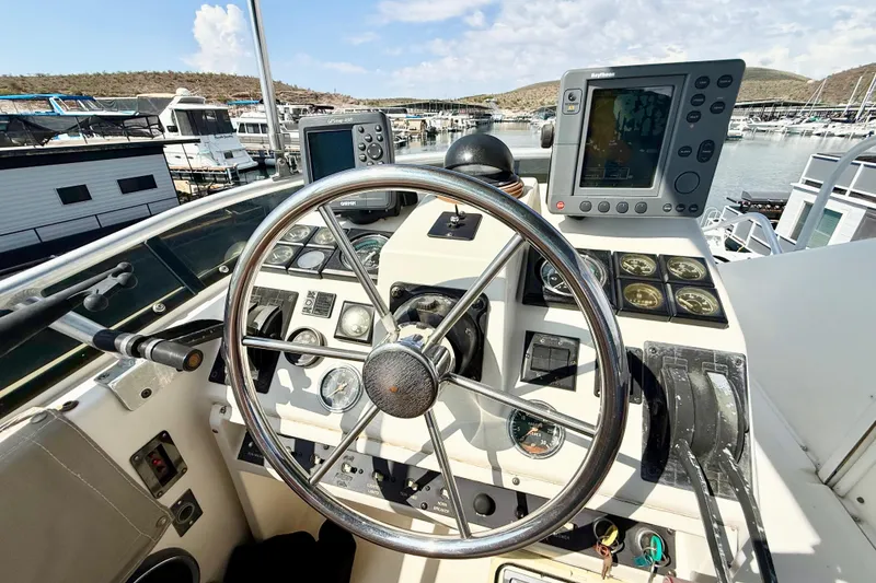 Slide: The Image of 1990 Luhrs 3400 Motor Yacht helm with steering wheel and navigation instruments at marina. - 32