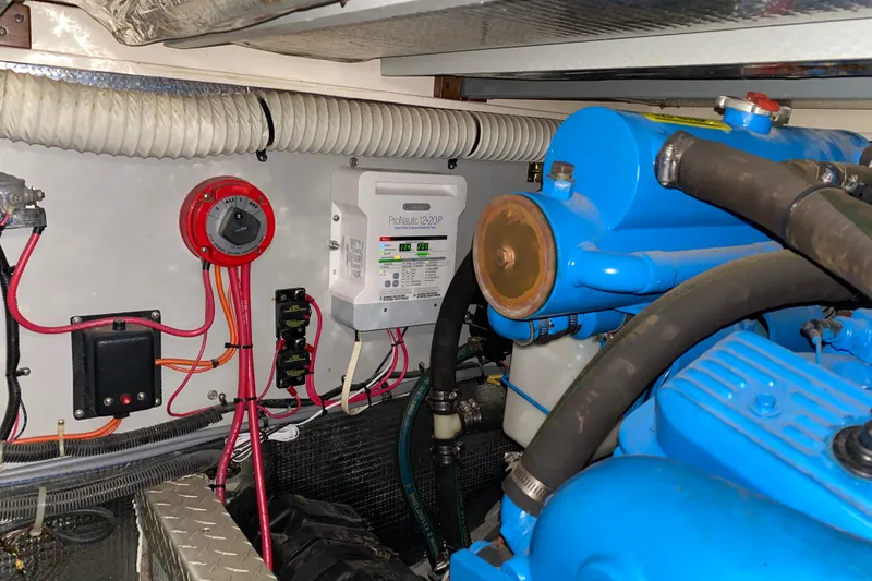 Slide: The Image of Engine room of 1990 Luhrs 3400 Motor Yacht with wiring and blue engine components. - 39