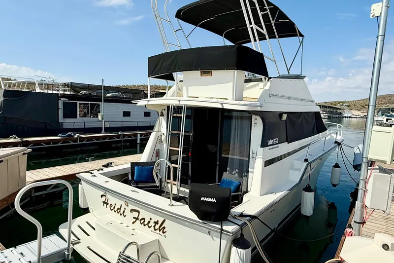 Slide: The Image of 1990 Luhrs 3400 Motor Yacht docked at marina, featuring "Heidi Faith" name on stern. - 4