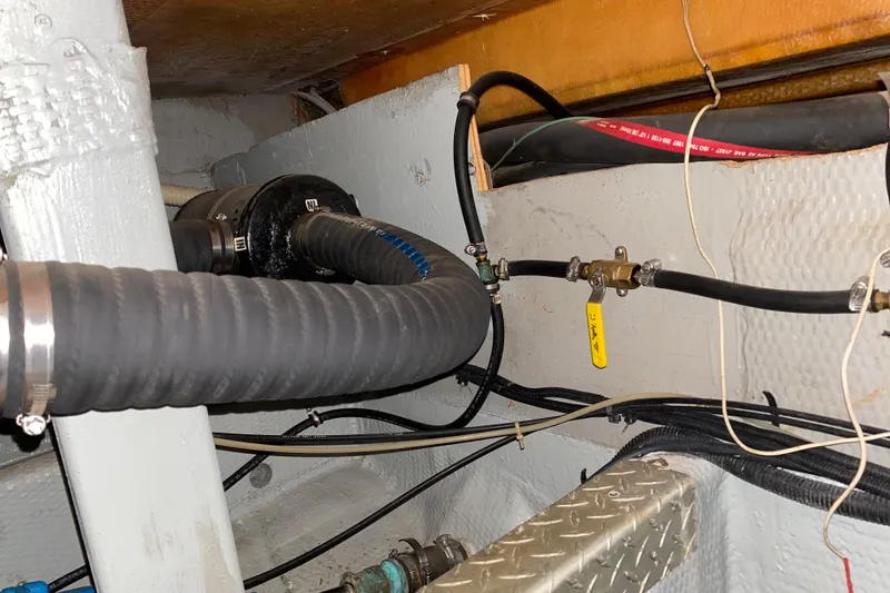 Slide: The Image of Engine room of 1990 Luhrs 3400 Motor Yacht with hoses and valves visible. - 42