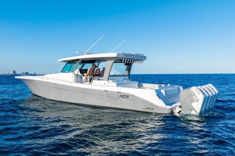 Slide: The Image of HCB 56 Suenos 2027 luxury boat cruising on open ocean under clear blue sky. - 1