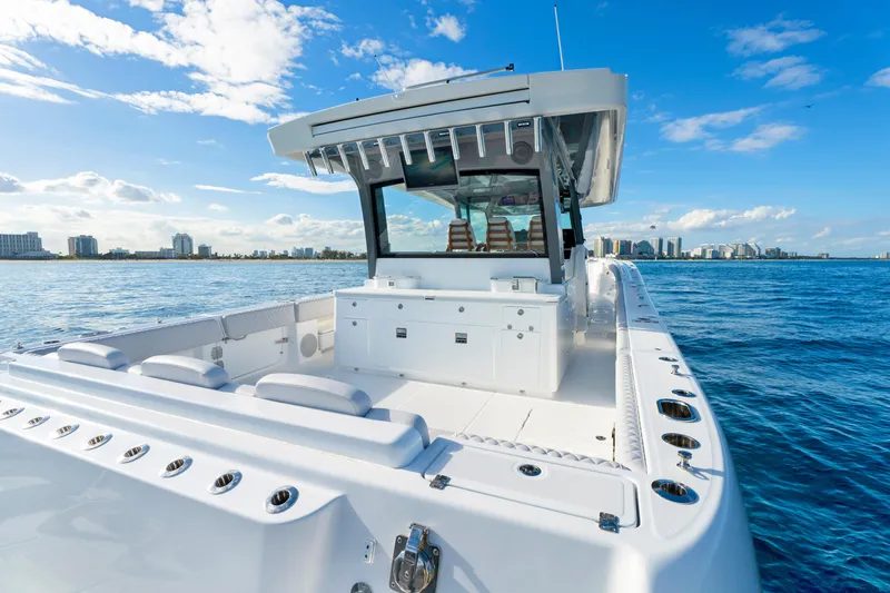 Slide: The Image of Luxury HCB 56 Suenos boat cruising near city skyline, 2027 model. - 17