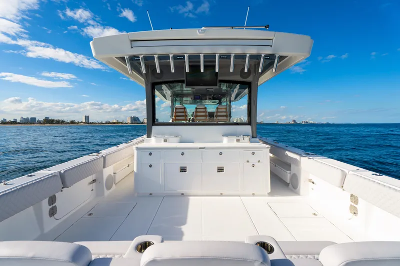 Slide: The Image of Luxury HCB 56 Suenos boat deck, 2027 model, cruising on open blue sea under clear skies. - 18