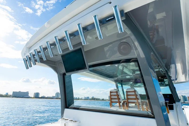 Slide: The Image of HCB 56 Suenos 2027 boat with rod holders and city skyline in background. - 19