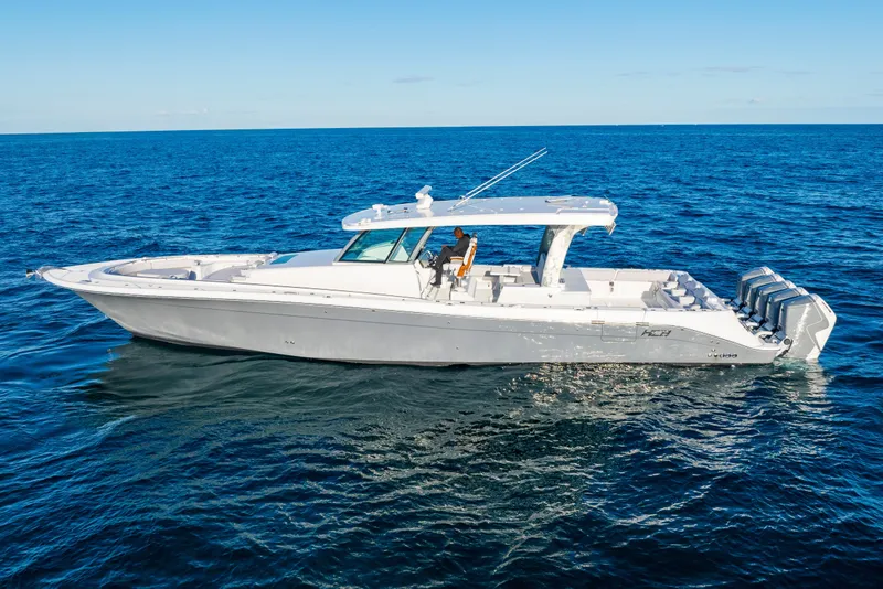 Slide: The Image of 2027 HCB 56 Suenos luxury boat cruising on open blue ocean waters. - 2