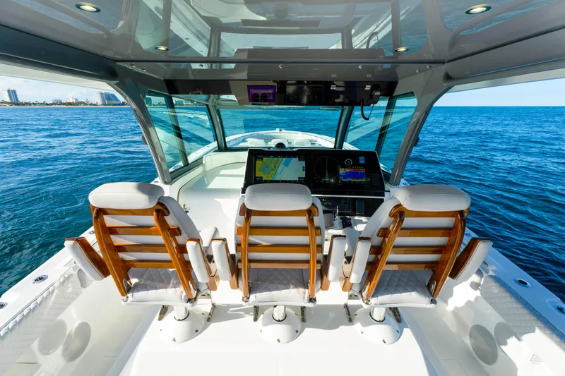 Slide: The Image of Cockpit view of 2027 HCB 56 Suenos boat with luxurious seating and ocean backdrop. - 27