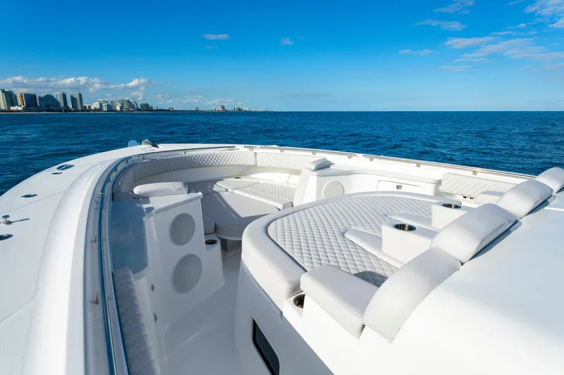 Slide: The Image of Luxurious 2027 HCB 56 Suenos yacht with spacious seating, cruising on open ocean near city skyline. - 31