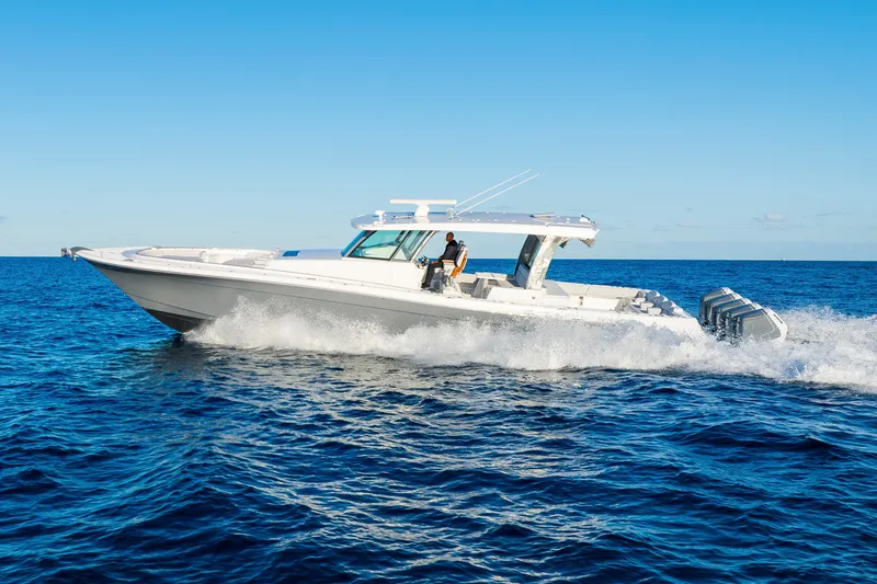 Slide: The Image of 2027 HCB 56 Suenos luxury boat cruising on open ocean under clear blue sky. - 44