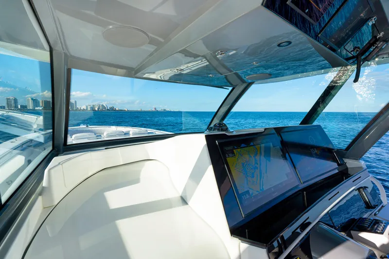 Slide: The Image of Interior view of 2027 HCB 56 Suenos yacht, featuring advanced navigation screens and ocean backdrop. - 56