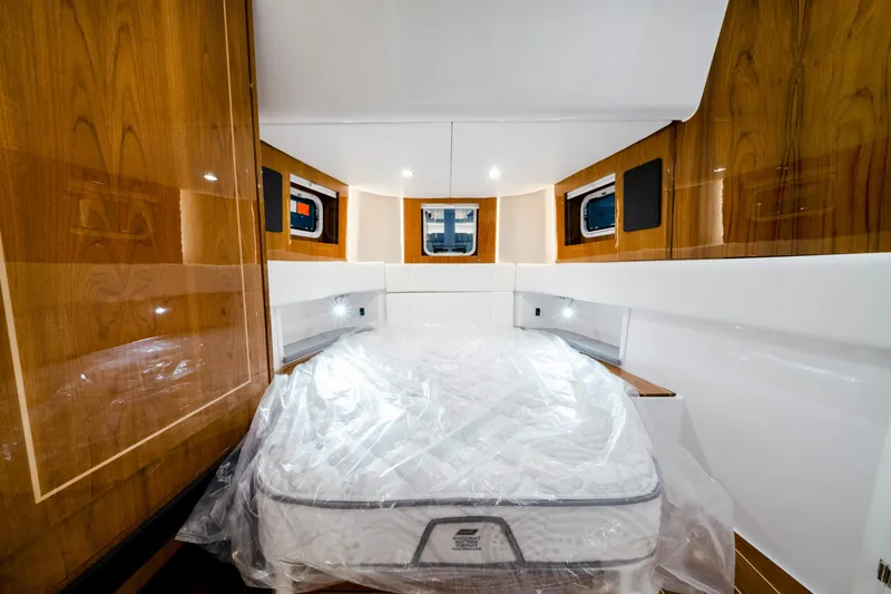 Slide: The Image of Luxurious cabin interior of 2027 HCB 56 Suenos yacht with wood paneling and bed. - 63