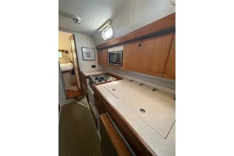 Slide: The Image of 2003 Morgan/Catalina 381 CC yacht interior kitchen with wooden cabinets and modern appliances. - 14