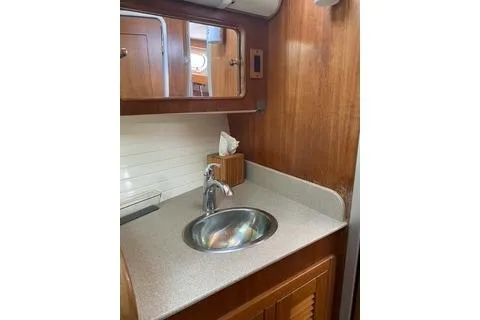 Slide: The Image of 2003 Morgan/Catalina 381 CC yacht bathroom with sink and wooden cabinetry. - 19