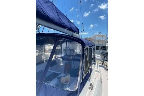 Slide: The Image of 2003 Morgan/Catalina 381 CC sailboat with blue canopy, docked under a clear sky. - 30