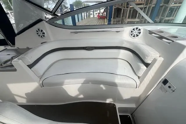 Slide: The Image of 2007 Rinker 280 Express Cruiser interior seating with white upholstery and speaker system. - 10