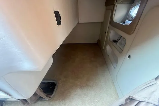 Slide: The Image of Interior cabin of 2007 Rinker 280 Express Cruiser, featuring beige upholstery and storage compartments. - 13