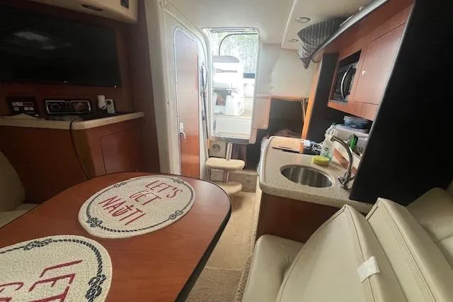 Slide: The Image of 2007 Rinker 280 Express Cruiser interior with kitchenette and seating area. - 17