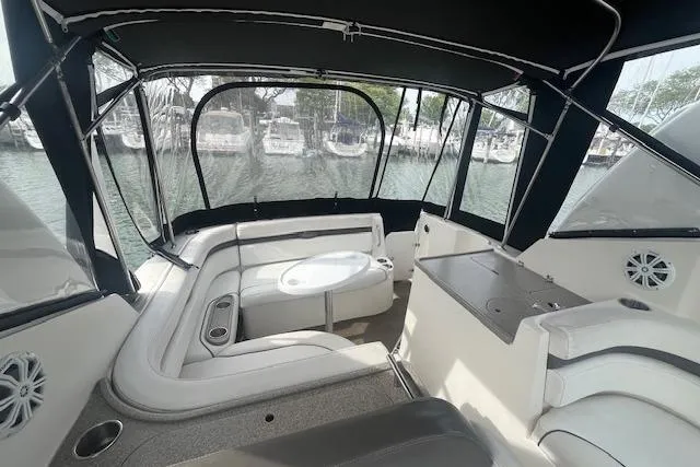 Slide: The Image of 2007 Rinker 280 Express Cruiser interior with seating and table, docked at marina. - 21
