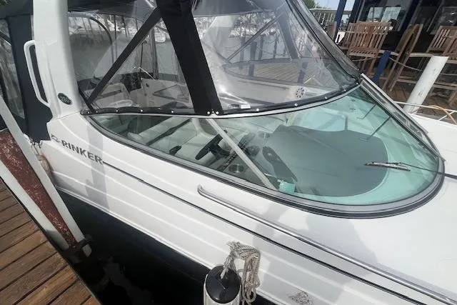 Slide: The Image of 2007 Rinker 280 Express Cruiser docked, featuring sleek design and clear windshield. - 5