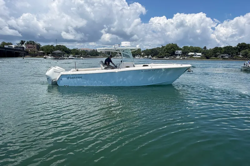 Slide: The Image of 2021 Sailfish 290 CC boat on calm water under a partly cloudy sky. - 15