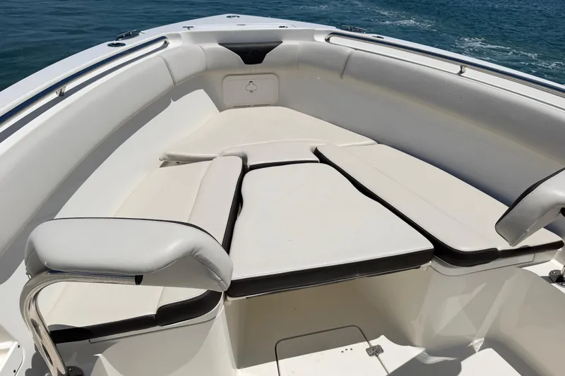 Slide: The Image of 2021 Sailfish 290 CC boat interior with cushioned seating, ocean in background. - 18