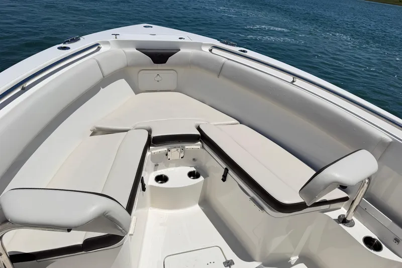 Slide: The Image of 2021 Sailfish 290 CC boat interior with cushioned seating and cup holders. - 20